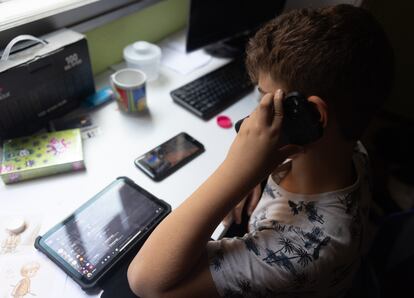 Un niño con una tableta y hablando a la vez por el teléfono móvil en octubre en Madrid.