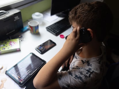Un niño con una tableta y hablando a la vez por el teléfono móvil en octubre en Madrid.
