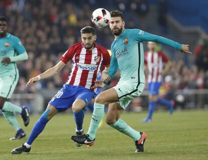 El jugador del Atlético de Madrid Yannick Ferreira Carrasco (izquierda) presiona a Gerard Piqué, del Barcelona.