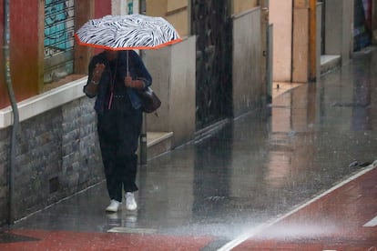 Una mujer se protege del aguacero en Valencia a primera hora de este viernes.