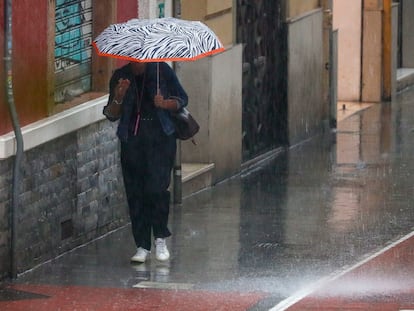 Una mujer se protege del aguacero en Valencia a primera hora de este viernes.