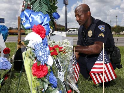 Un polic&iacute;a de Baton Rouge rinde homenaje a los agentes asesinados en el lugar del atentado, el lunes.   