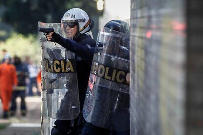 PM aponta arma para manifestantes durante protesto contra o Governo Temer, na Esplanada dos Ministérios. 