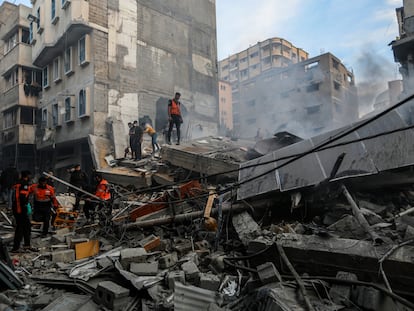 Un grupo de palestinos inspecciona los escombros de un edificio derruido por un bombardeo israelí este lunes en Jan Yunis, en el sur de Gaza.