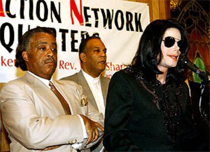 El reverendo Al Sharpton, a la izquierda, escucha a Michael Jackson el sábado en Harlem.