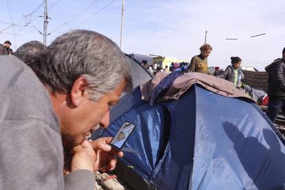 Un migrante se asea con un espejo pequeño entre las tiendas de campaña del campo de Idomeni (Grecia).