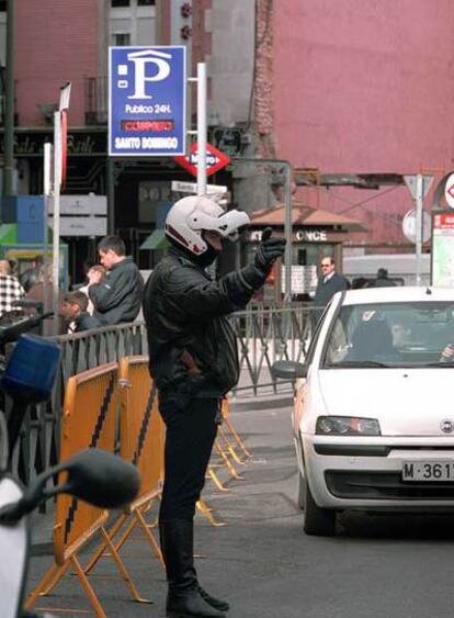 Un policía impide la entrada a un garaje público.