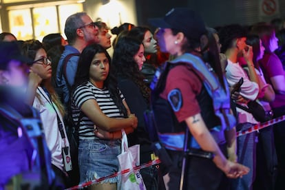 Una oficial de policía observa a la multitud que se reúne afuera del hotel.