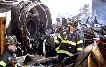 Bomberos rastrean el lugar del accidente entre los restos del avión siniestrado en Nueva York.