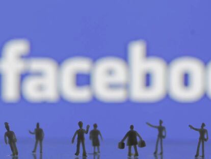 Figuras creadas con una impresora 3D ante el logo de Facebook. 