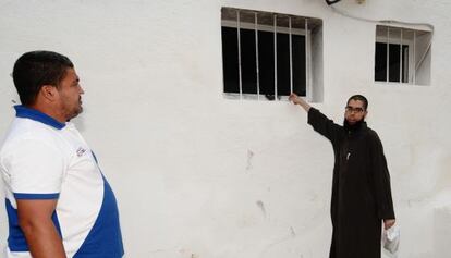 Un miembro de la comunidad musulmana de Tarragona muestra la ventana usada para lanzar el material incendiario.