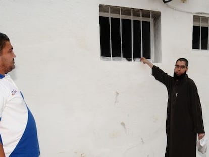 Un miembro de la comunidad musulmana de Tarragona muestra la ventana usada para lanzar el material incendiario.