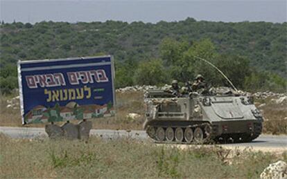 Un blindado israelí circula junto a un cartel que reza 'Bienvenido a Emanuel', colonia judía en Cisjordania.