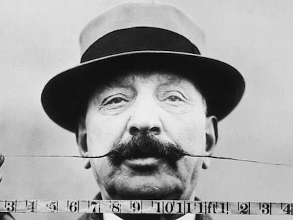 Retrato de un hombre que mide la longitud de su bigote con una cinta métrica en 1905.