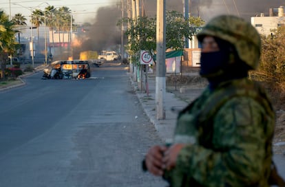 Desde la madrugada de este 5 de enero, las balaceras, los narcobloqueos y los incendios ocasionados por integrantes del crimen organizado, aterrorizan a la población sinaloense. En la imagen, un elemento del Ejército mexicano junto a un vehículo calcinado, en Culiacán. 