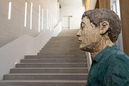 'Hombre con los ojos cerrados', escultura de madera de Stephan Balkenhol, a los pies de la gran escalera diseñada por el arquitecto Emilio Tuñón en el Museo Helga de Alvear de Cáceres.