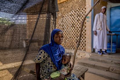 Habsou Zabeïrou espera sentada con su bebé Mahamadou al pie de las escaleras del centro de salud de Tama. Mientras espera su turno, Habsou, de 15 años, habla de su primera experiencia como madre.