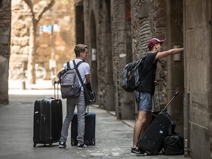 Dos viajeros entran a un piso de alquiler turístico en Barcelona, en mayo de 2018.