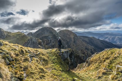 Una joven observa el paisaje desde la cima de la montaña de Aiako Harria.