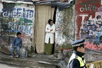 Una mujer y su hijo contemplan las operaciones de demolición de parte del poblado de La Quinta, en Fuencarral-El Pardo.