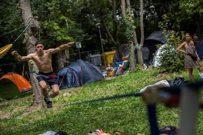 Un hombre realiza ejercicios sobre un 'slackline' durante el festival Sziget celebrado en la isla de Shipyard, al norte de Budapest (Hungría).