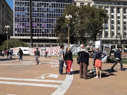 Turistas observan uno de los atriles colocados en la Plaza de Mayo, ahora junto a los pañuelos pintados de las Madres de Plaza de Mayo.