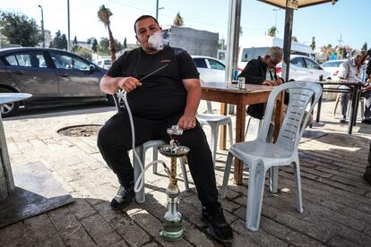 Un hombre fuma una pipa en la terraza de un local cercano a la Puerta de Damasco, este viernes en Jerusalén.
