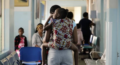 Una madre carga a su hija en la espalda a su llegada al Hospital Central de Maputo, capital de Mozambique.