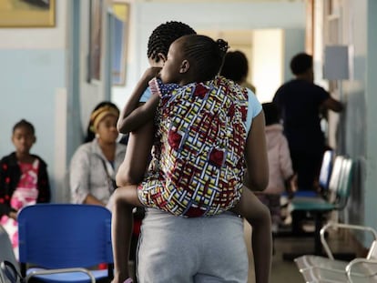Una madre carga a su hija en la espalda a su llegada al Hospital Central de Maputo, capital de Mozambique.