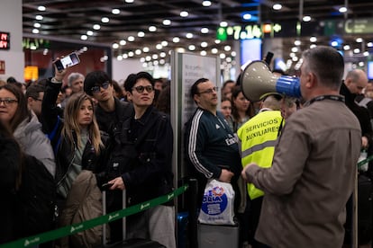 En la estación de Sants, centenares de pasajeros esperan para coger su tren.