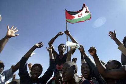 Unos subsaharianos enarbolan la bandera del Frente Polisario en el campamento de Bir Lehlu donde han sido acogidos.