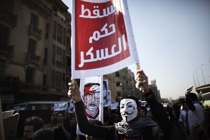 Un estudiante egipcio portando una máscara de Guy Fawkes de V de Venganza sostiene una pancarta en la que se lee "Abajo el régimen militar" hoy en El Cairo.