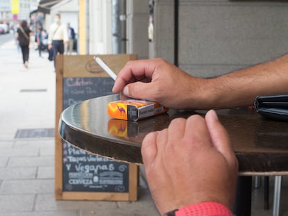 Una persona fuma en una terraza durante el primer día de la prohibición en Galicia.
