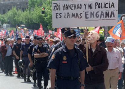 Un policía municipal disfrazado de alcalde de Madrid se manifiesta con otros compañeros por la calle de Génova.