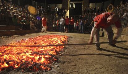 Un momento de la preparación de las brasas colocadas en el anfiteatro de la ermita de la Peña, en el pueblo soriano de San Pedro Marique,