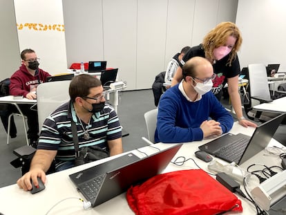 Una profesora trabaja con dos alumnos del itinerario en Marketing Digital y Comunicación, en las instalaciones de Por Talento Digital en Madrid.