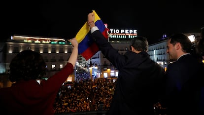 En enero de 2020, la presidenta de Madrid, Isabel Díaz Ayuso, el presidente interino de Venezuela, Juan Guaidó, y el vicepresidente regional, Ignacio Aguado, saludan desde el balcón de la sede del Gobierno madrileño.
