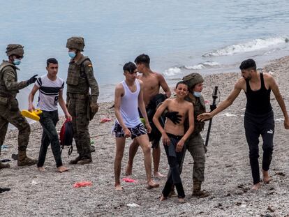 Varios menores llegan a las playas de Ceuta, donde son recibidos por miembros del Ejército.