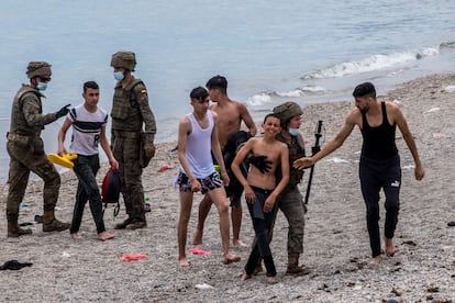 Varios menores llegan a las playas de Ceuta, donde son recibidos por miembros del Ejército.