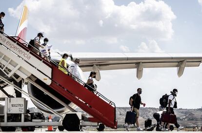 Viajeros descienden de la escalerilla de un avión de Iberia.