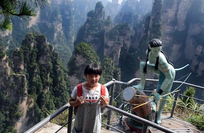 Una niña posa con una escultura de uno de los personajes de 'Avatar' en el alto de Yuanjiajie, en el parque nacional de Zhangjiajie donde el famoso pilar Qiankun ha sido rebautizado como Aleluya, el nombre de la montaña flotante de la película de James Cameron.