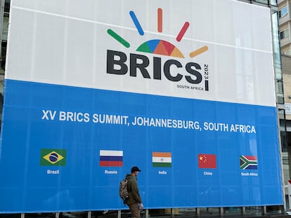 Una persona pasa por delante del Centro de Convenciones de Sandton, que acoge la cumbre de los BRICS, en Johannesburgo (Sudáfrica) el sábado pasado.