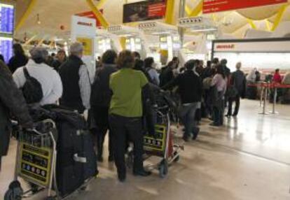 Decenas de turistas hacen cola en los mostradores de una compañía aérea en el aeropuerto de Madrid-Barajas. EFE/Archivo