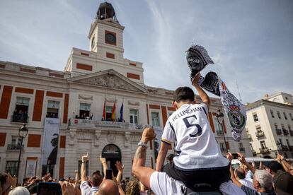 La afición celebra la victoria ante los jugadores del Real Madrid, que han levantado la copa desde el balcón de la Real Casa de Correos, este domingo.