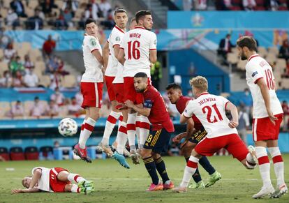 El balón traspasa la barrera polaca en un tiro libre de España.