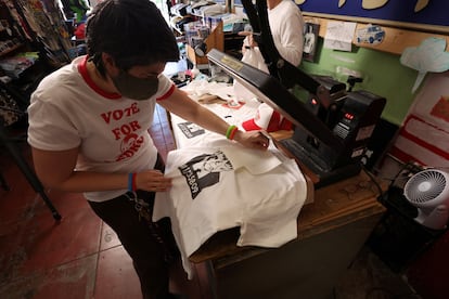 An employee at a printing company in Los Angeles, California, prints T-shirts with Trump's mugshot.