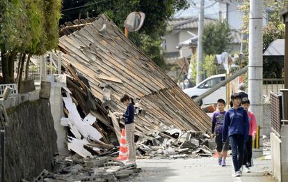 Un grupo de niños pasa junto a los escombros de una casa en la ciudad de Mashiki (Japón), el 15 de abril de 2016.