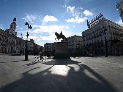 Un repartidor cruza en bicicleta la madrileña Puerta del Sol, vacía, el pasado sábado.