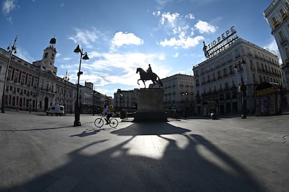 Un repartidor cruza en bicicleta la madrileña Puerta del Sol, vacía, el pasado sábado.