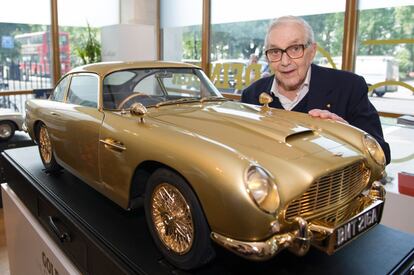 Ken Adam con el Aston Martin diseñado para la saga de James Bond.